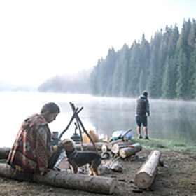 People fishing with their dog on the shore